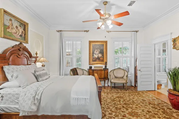 a bedroom with a bed a chandelier and a large window