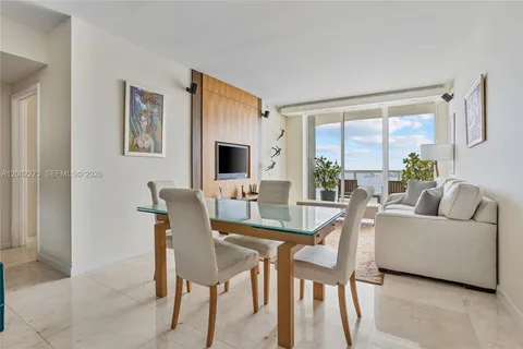 a living room with furniture a rug and kitchen view