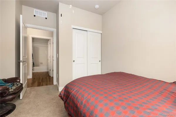 a bathroom with a granite countertop sink a toilet a mirror a vanity and shower