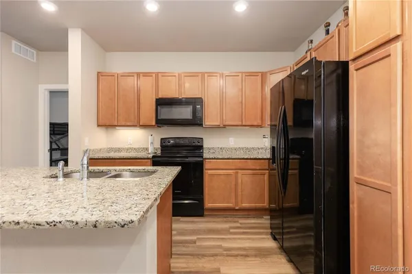 a kitchen with stainless steel appliances granite countertop a refrigerator sink and stove