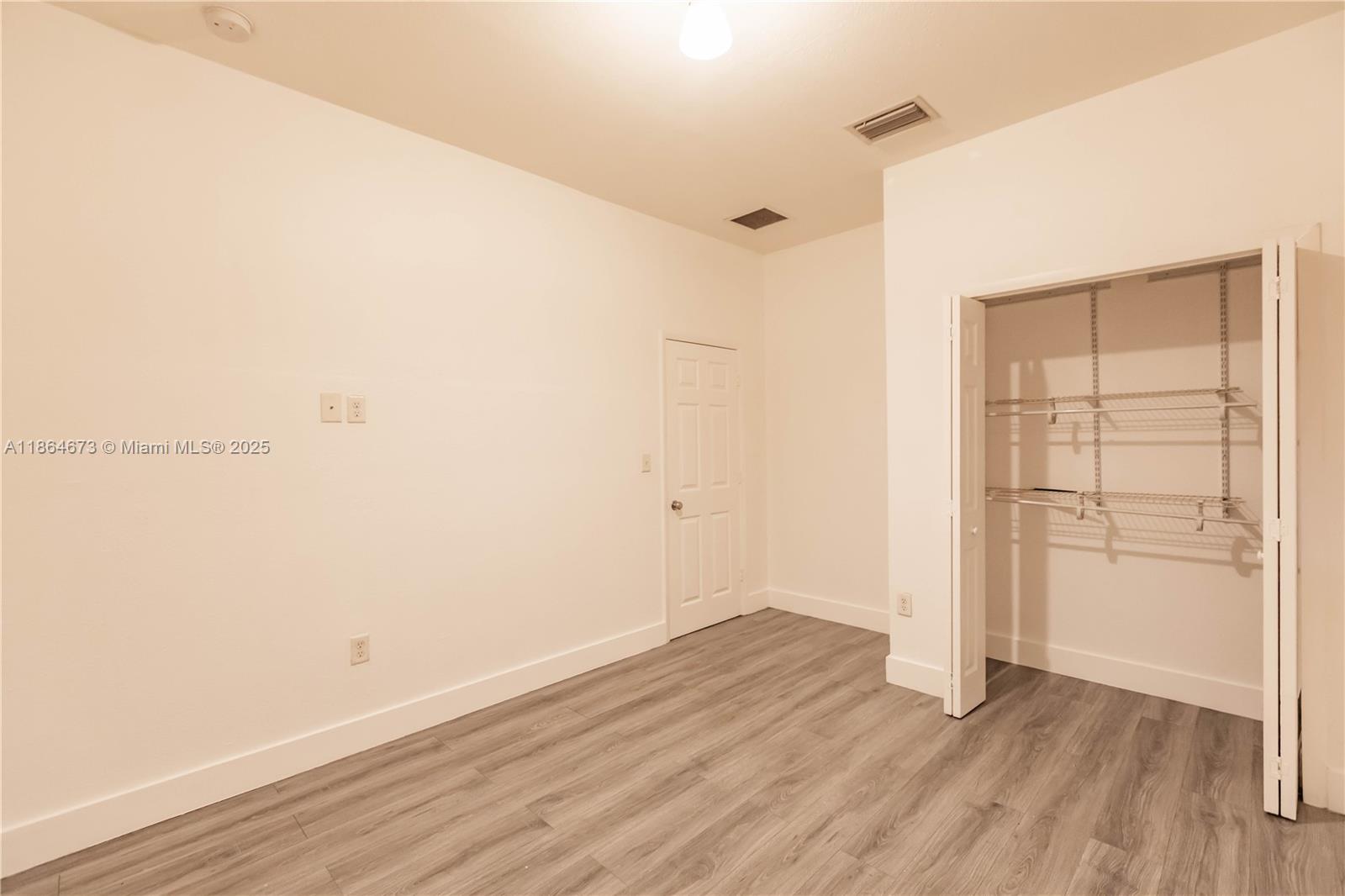 445 Northwest 77th Street, Unit 445 Miami, FL 33150 - Photo 13 of 20 an empty room with wooden floor