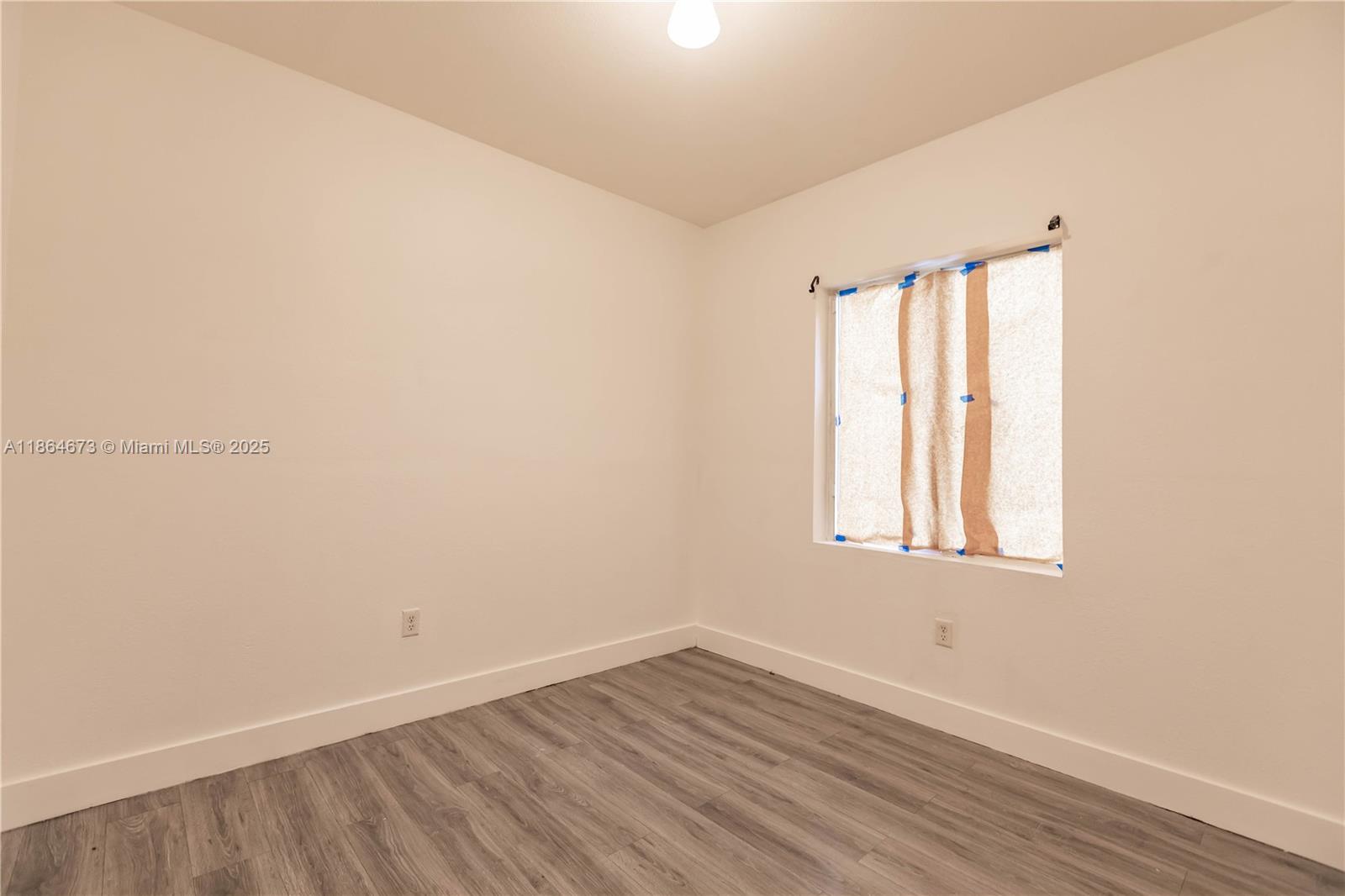 445 Northwest 77th Street, Unit 445 Miami, FL 33150 - Photo 16 of 20 an empty room with wooden floor and windows