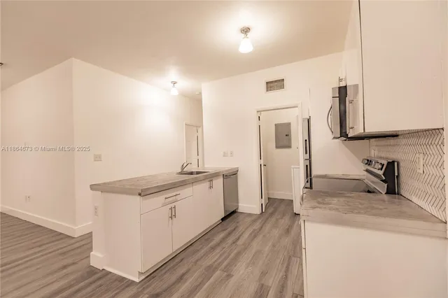 a kitchen with a sink stove and cabinets