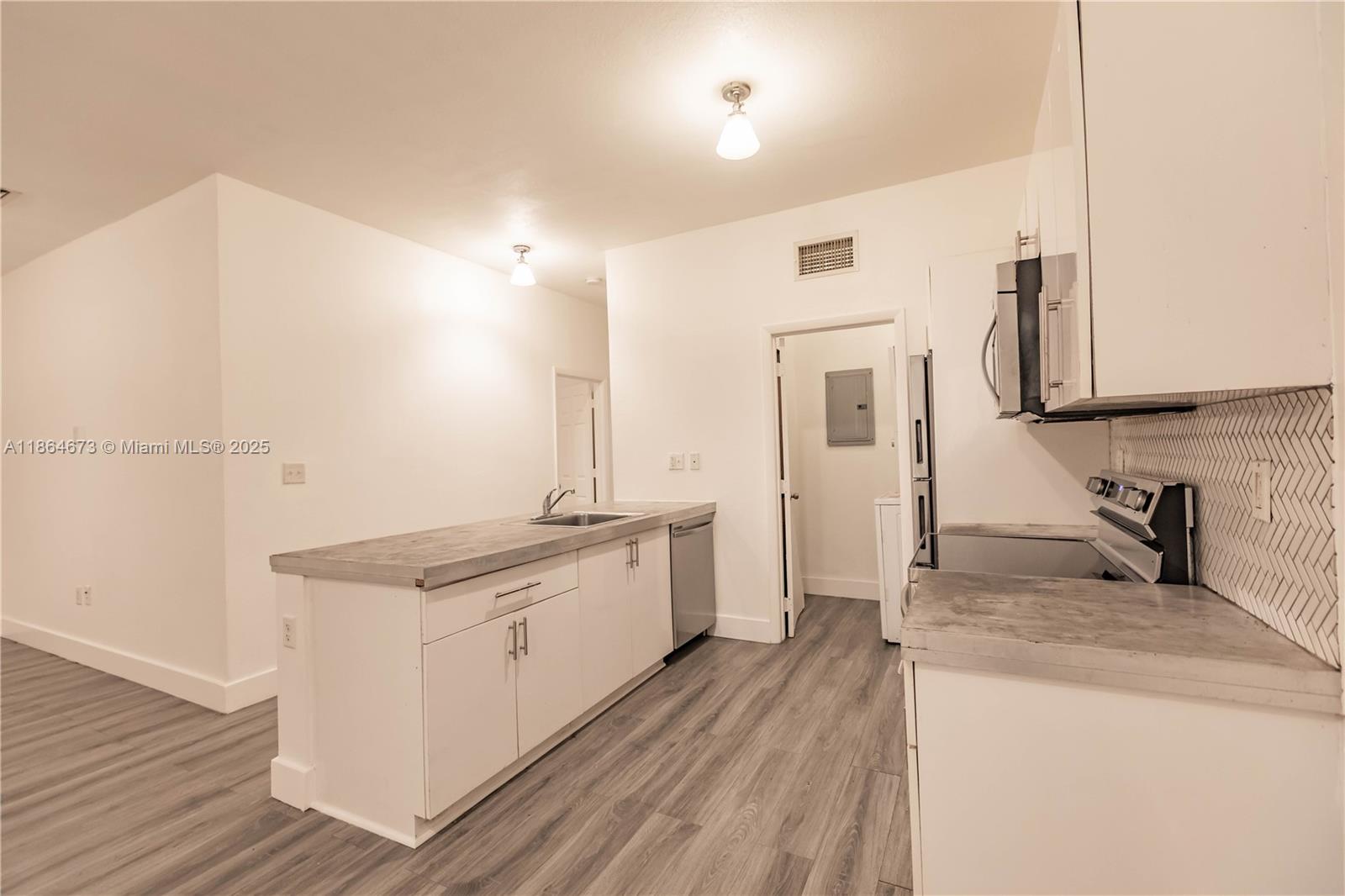 445 Northwest 77th Street, Unit 445 Miami, FL 33150 - Photo 4 of 20 a kitchen with a sink stove and cabinets