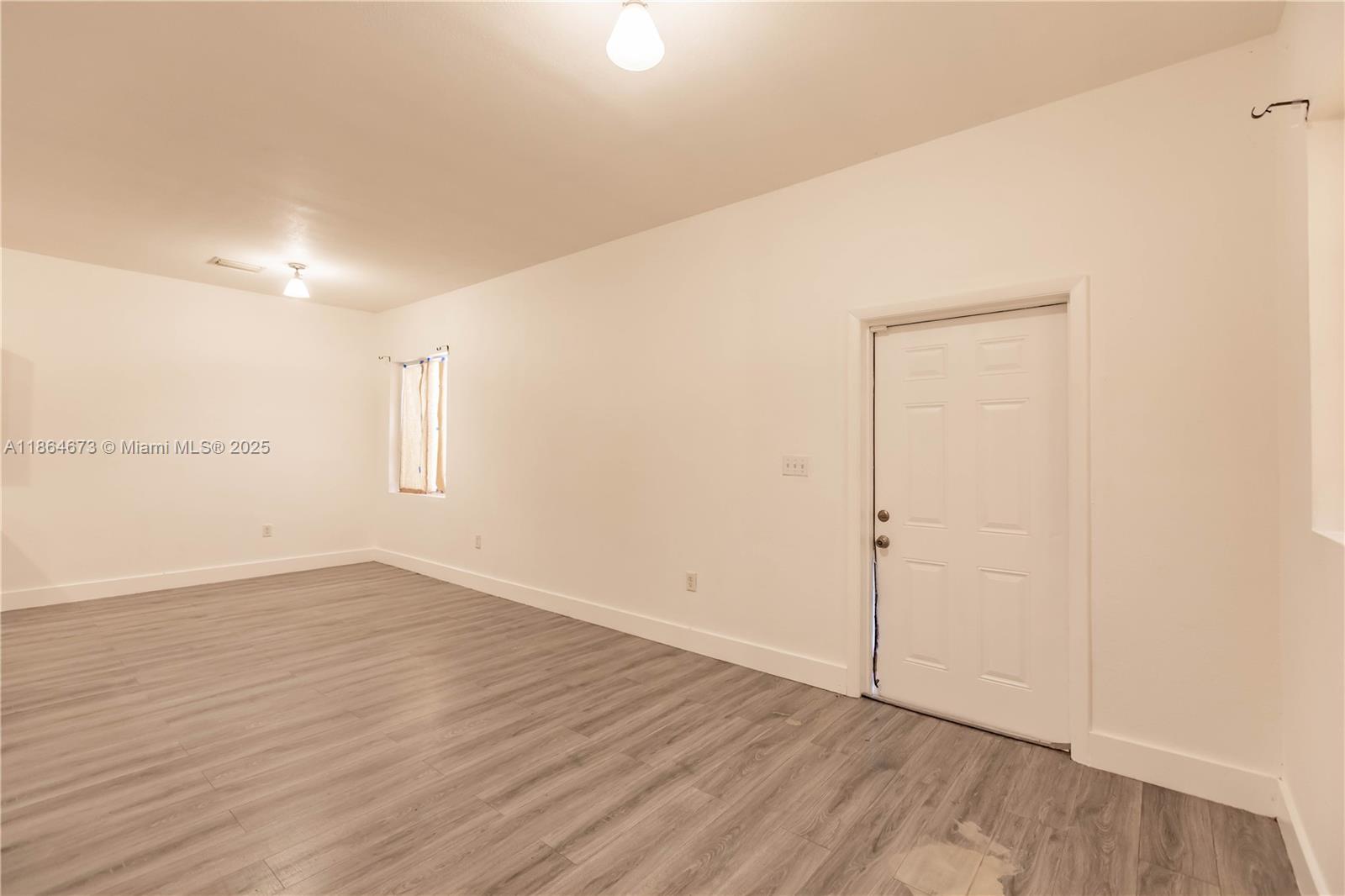445 Northwest 77th Street, Unit 445 Miami, FL 33150 - Photo 8 of 20 a view of an empty room with wooden floor