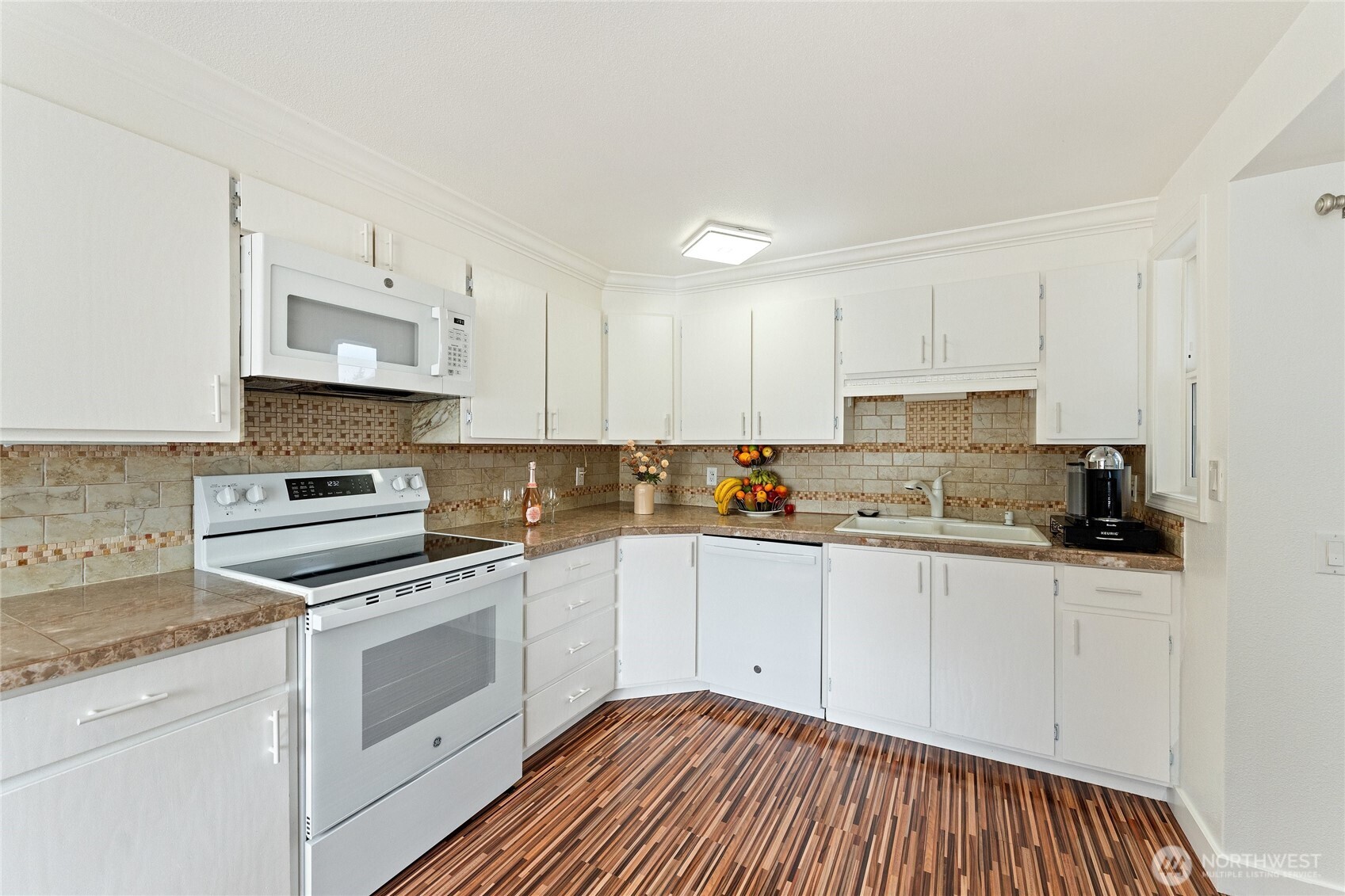 10107 Meridian Avenue Everett, WA 98208 - Photo 6 of 26 a kitchen with granite countertop white cabinets sink and stainless steel appliances