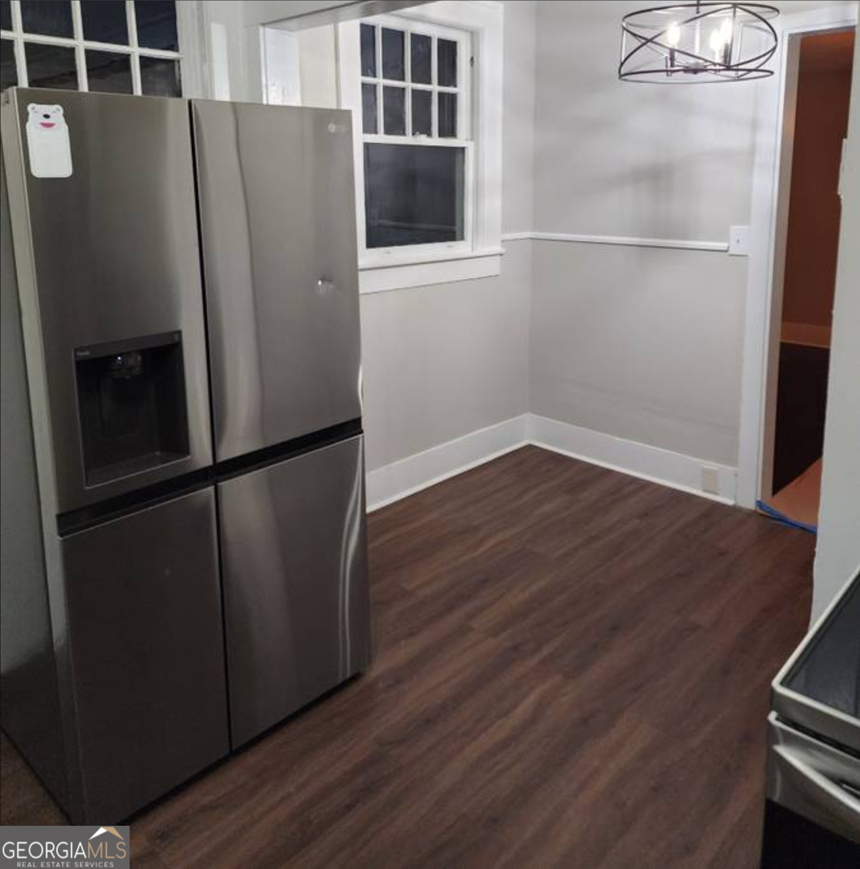 919 Inverness Avenue Macon, GA 31204 - Photo 5 of 9 a view of a refrigerator in kitchen and an empty room with wooden floor