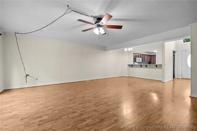 a view of a livingroom with a ceiling fan and wooden floor