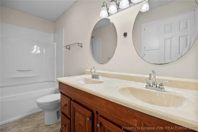 a bathroom with a double vanity sink mirror and toilet
