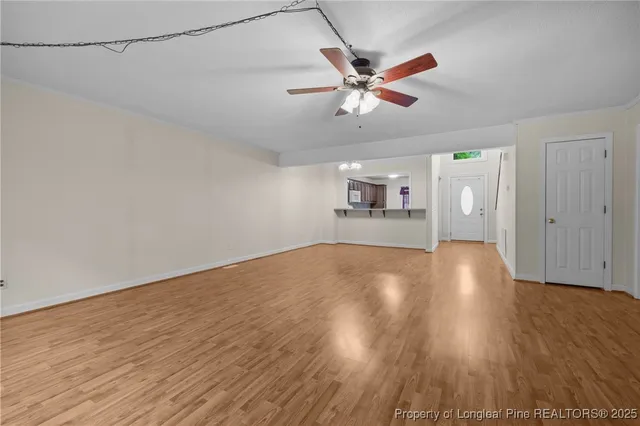 a view of empty room with wooden floor and window