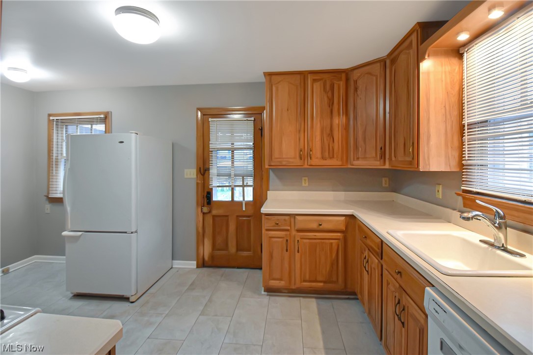 1068 Rushleigh Road Cleveland Heights, OH 44121 - Photo 10 of 22 Kitchen featuring sink, a healthy amount of sunlight, white appliances, and light tile floors