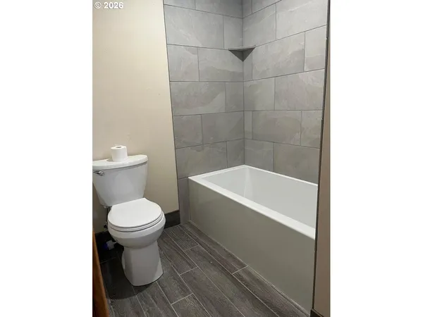 a white toilet sitting next to a bathtub