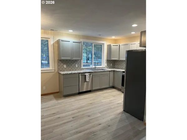 a kitchen with stainless steel appliances granite countertop a sink and a refrigerator