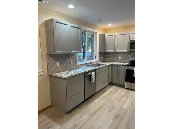 a kitchen with stainless steel appliances granite countertop a sink and a granite counter tops