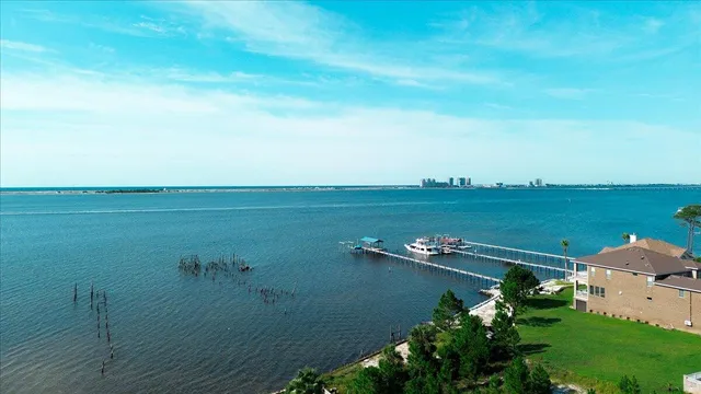 an aerial view of residential house with outdoor space and trees all around