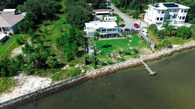 an aerial view of residential houses with outdoor space and lake view