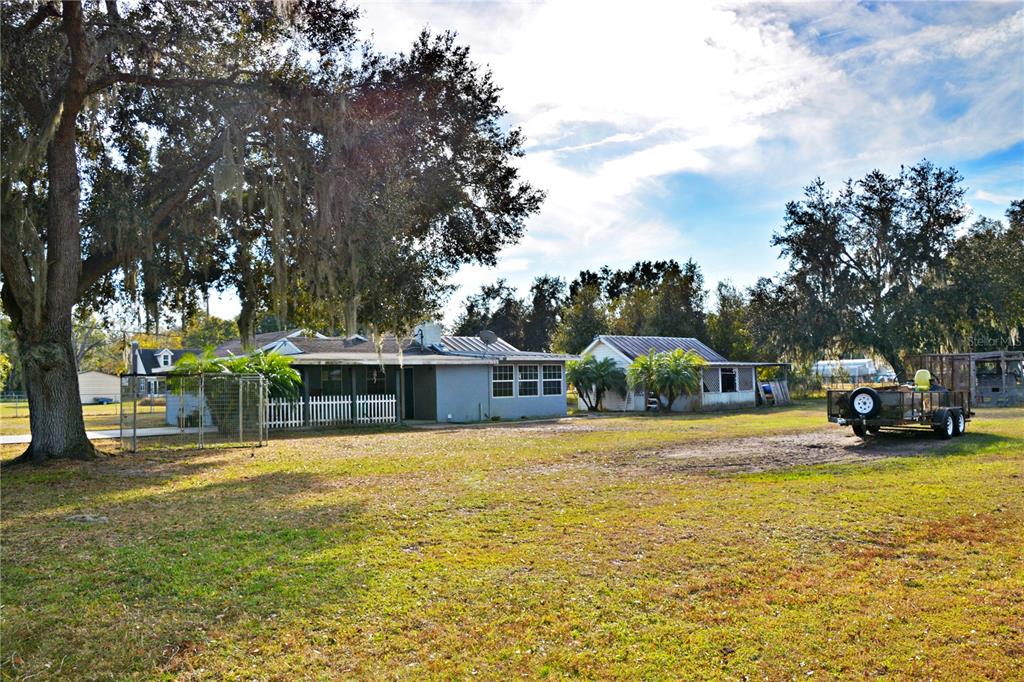5528 Cherry Road Lakeland, FL 33810 - Photo 40 of 47 a front view of a house with a big yard and potted plants and large tree