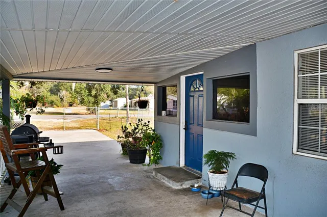 a view of a porch with chairs and potted plants