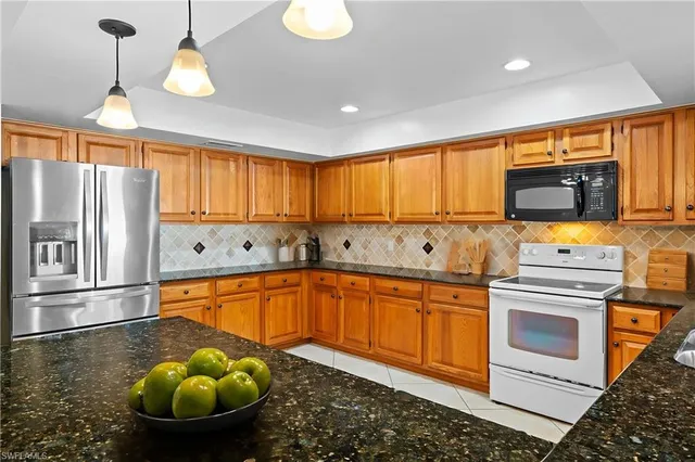 a kitchen with stainless steel appliances granite countertop a sink a stove cabinets and living room view