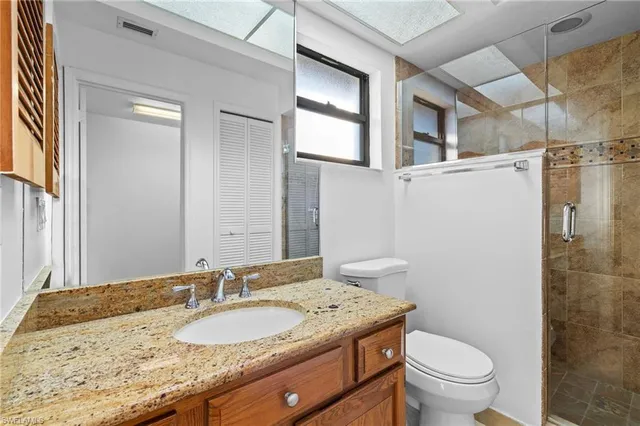 a bathroom with a granite countertop sink toilet and shower