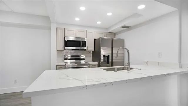 a large kitchen with kitchen island a sink stainless steel appliances and cabinets