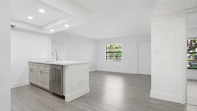an empty room with wooden floor and window