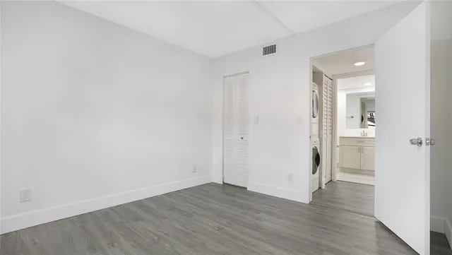 an empty room with wooden floor and window