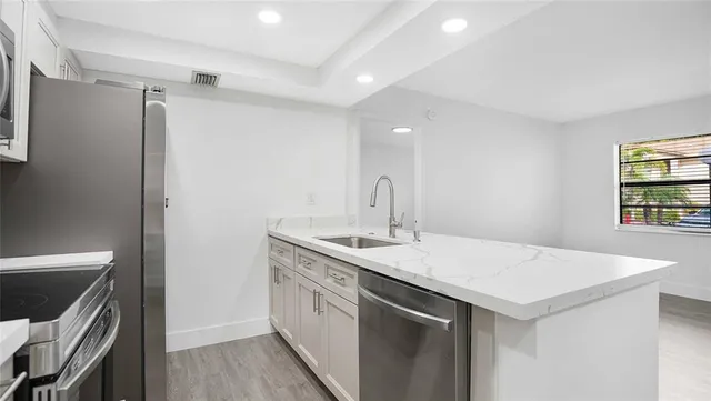 a kitchen with a sink and stainless steel appliances