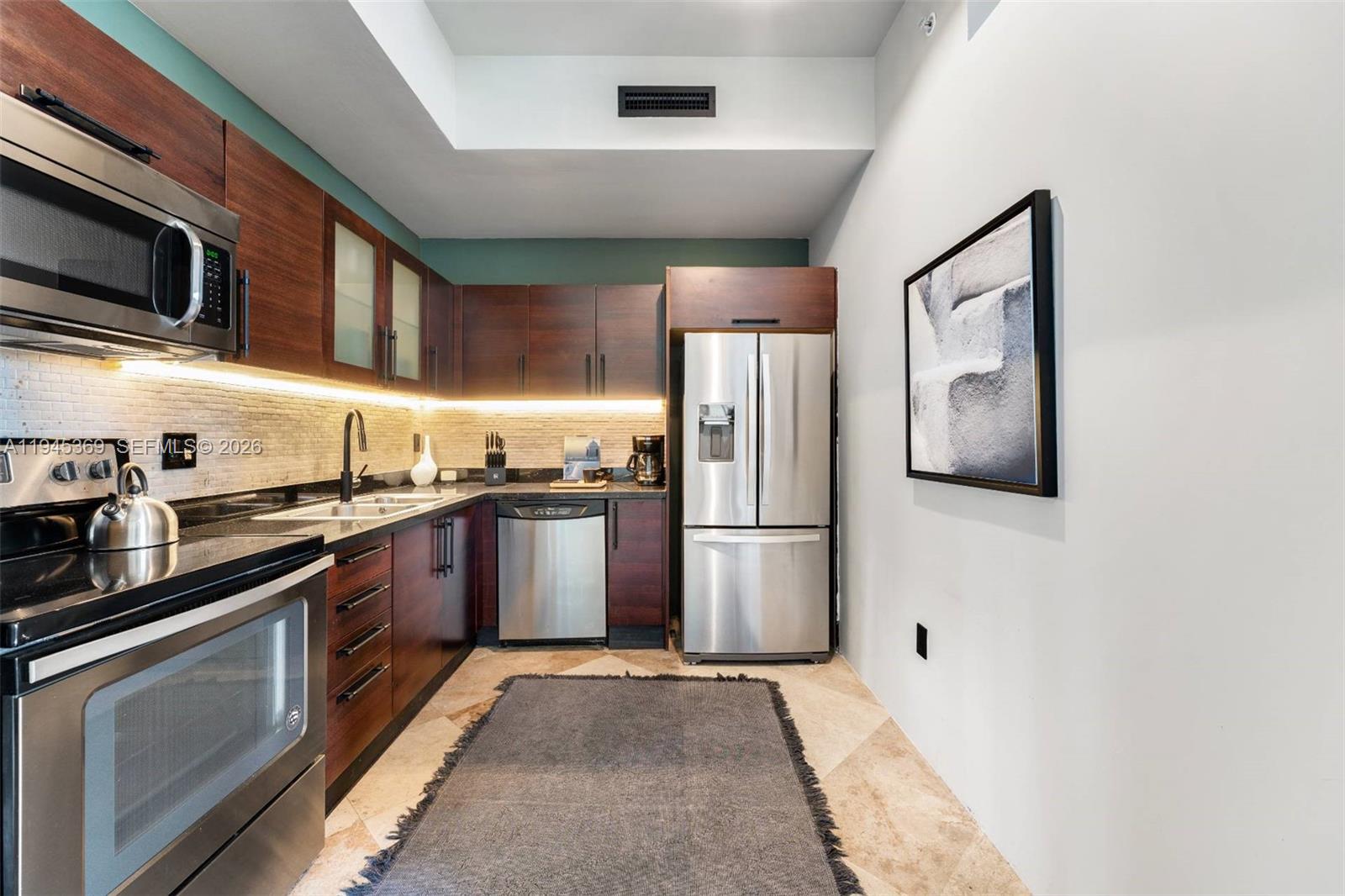 3250 Grand Avenue, Unit 306 Miami, FL 33133 - Photo 16 of 32 a kitchen with stainless steel appliances granite countertop a refrigerator a stove top oven a sink and dishwasher