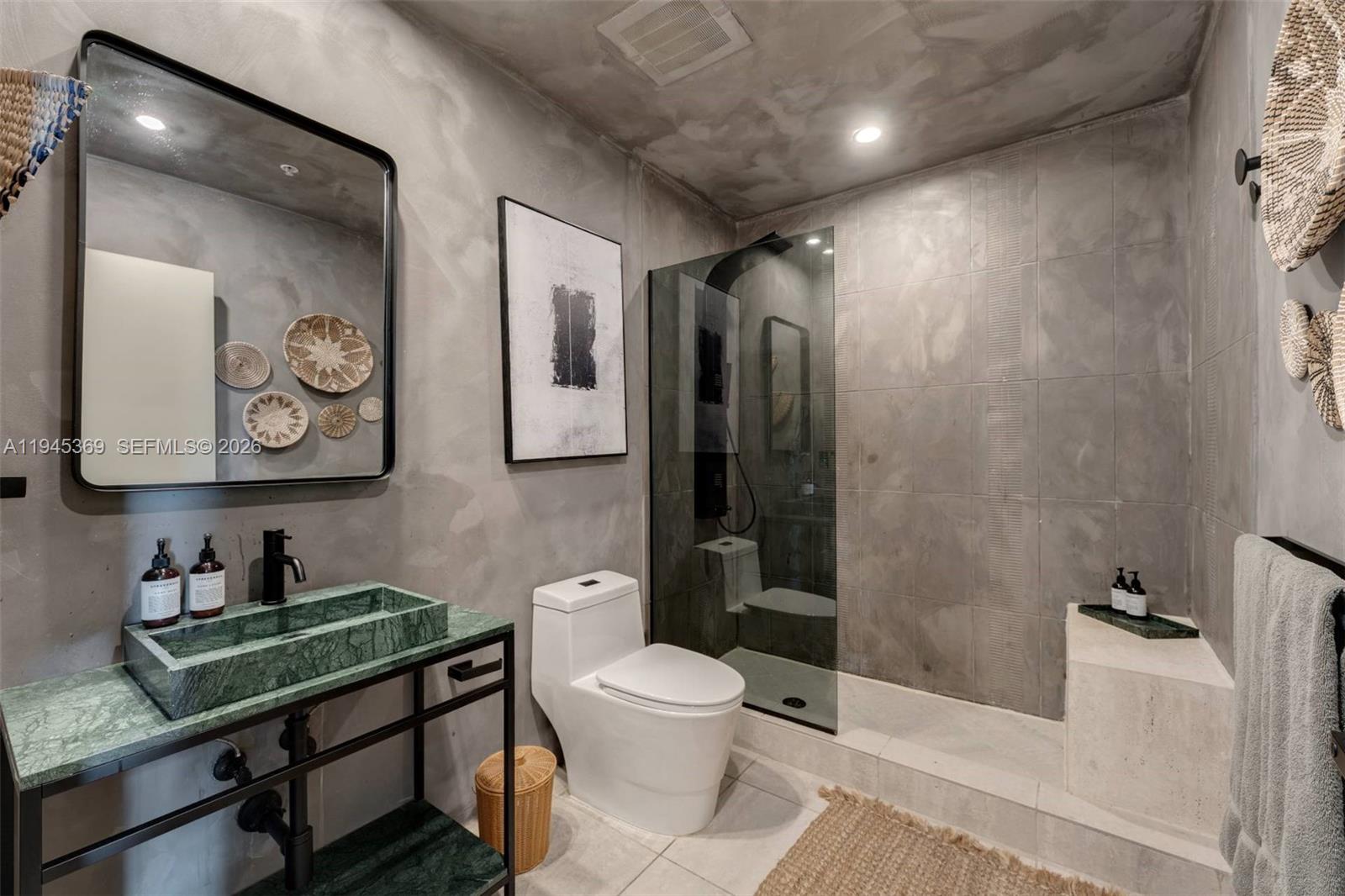 3250 Grand Avenue, Unit 306 Miami, FL 33133 - Photo 17 of 32 a bathroom with a toilet sink and mirror