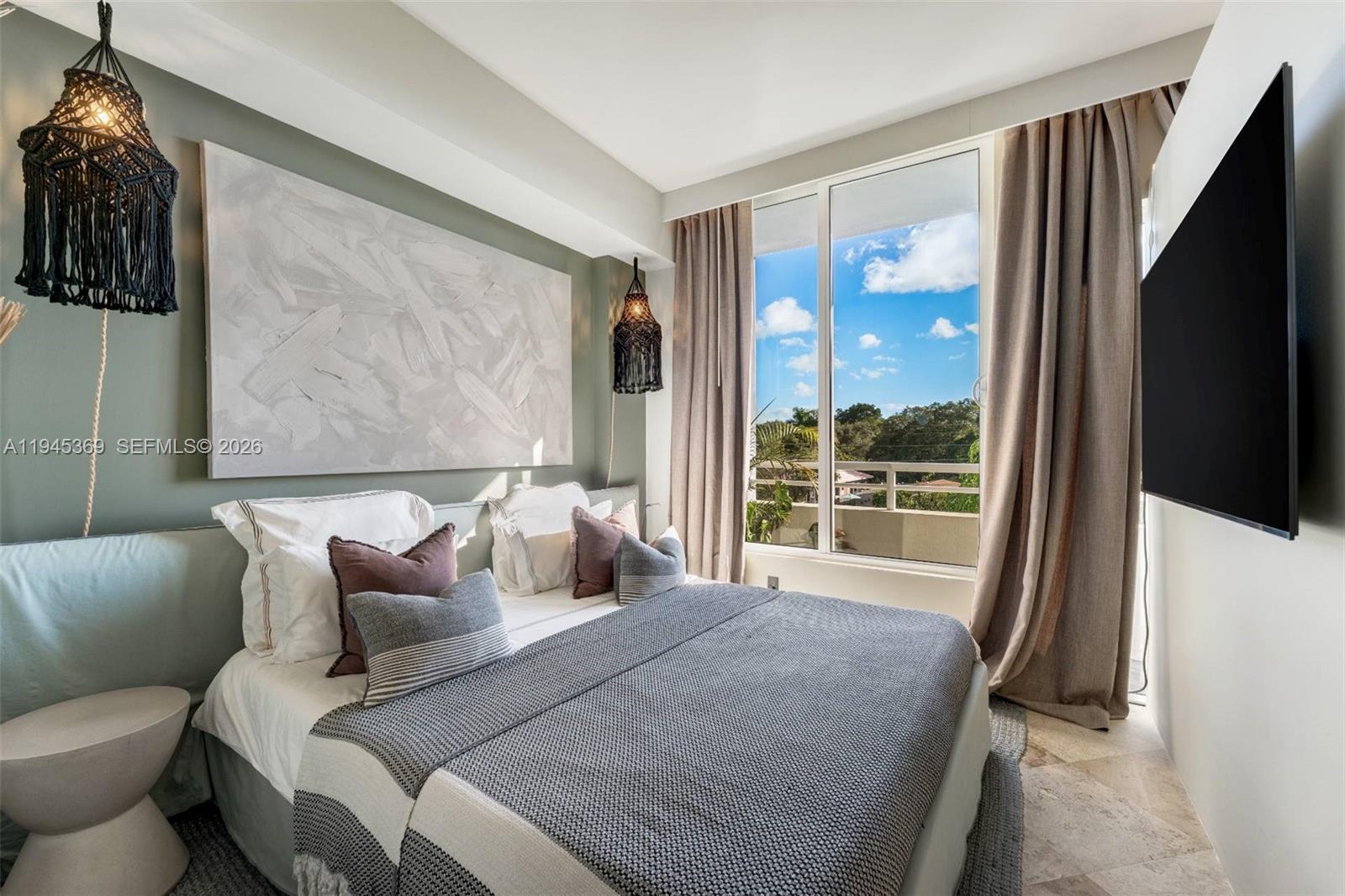 3250 Grand Avenue, Unit 306 Miami, FL 33133 - Photo 21 of 32 a bedroom with a bed and a flat tv screen next to a window