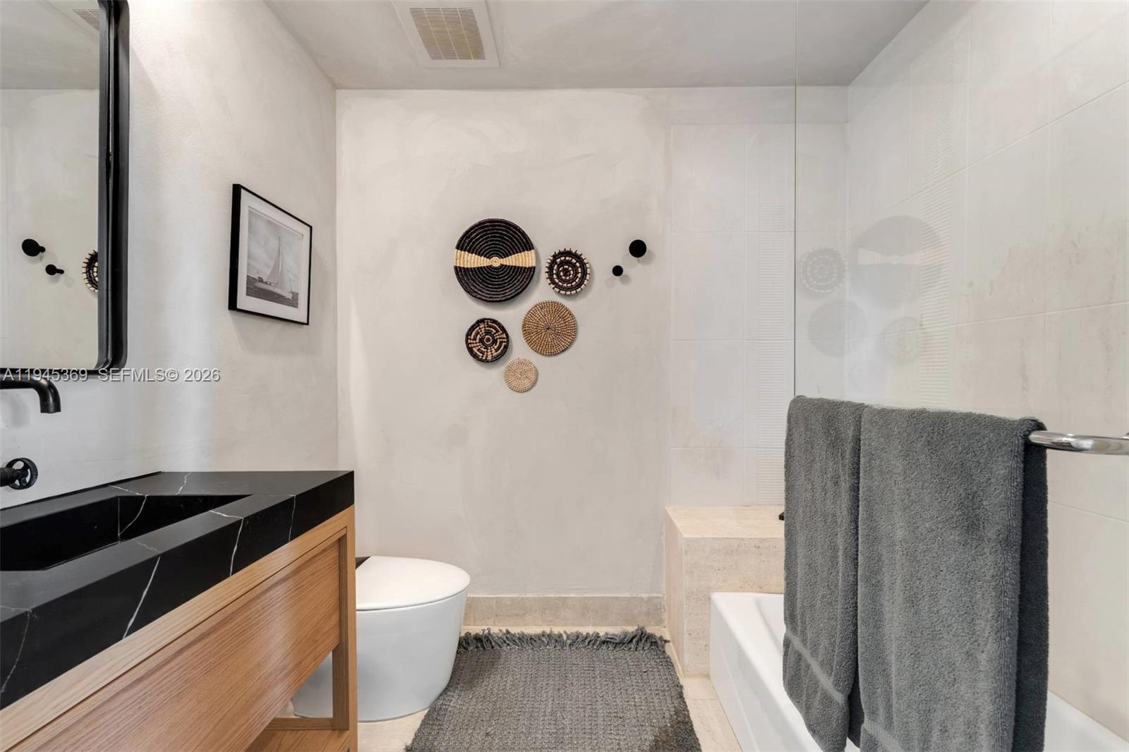 3250 Grand Avenue, Unit 306 Miami, FL 33133 - Photo 23 of 32 a bathroom with a granite countertop sink toilet and shower