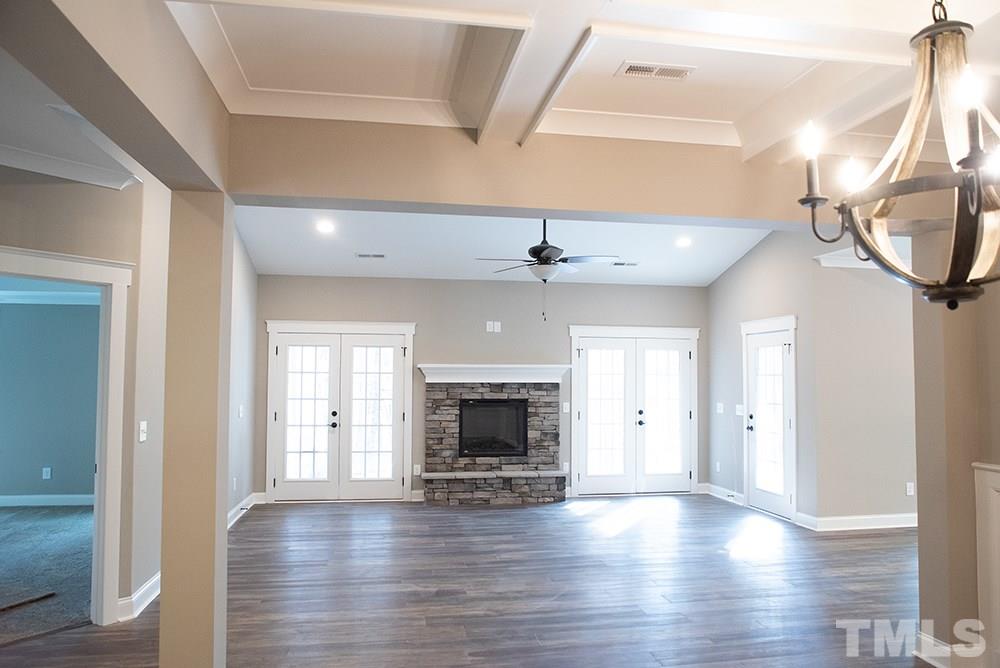 1426 Bowmantown Road Roxboro, NC 27574 - Photo 12 of 28 an empty room with wooden floor fireplace and windows