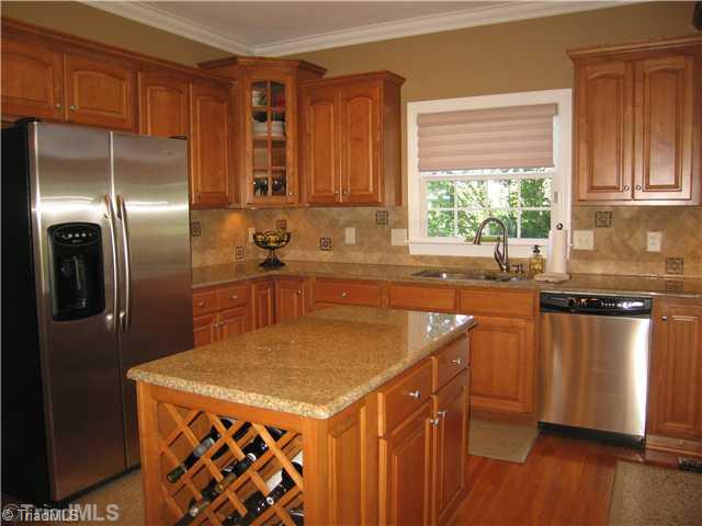 5810 Crutchfield Farm Road Oak Ridge, NC 27310 - Photo 3 of 16 Kitchen. This wonderful kitchen has stainless steel appliances, granite countertops and island, tiled backsplash, and is ready to accommodate your inner chef!
