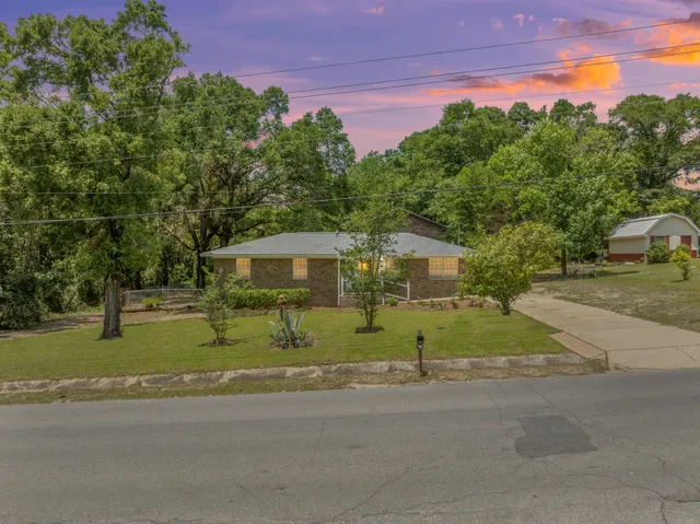 a yellow house with trees in front of it
