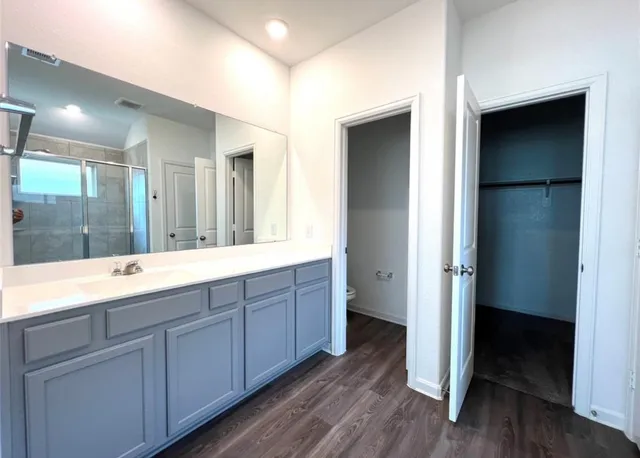 a bathroom with a granite countertop sink mirror and shower