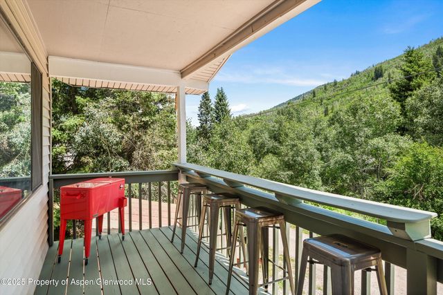 a view of a deck with furniture and barbeque grill with wooden floor and fence