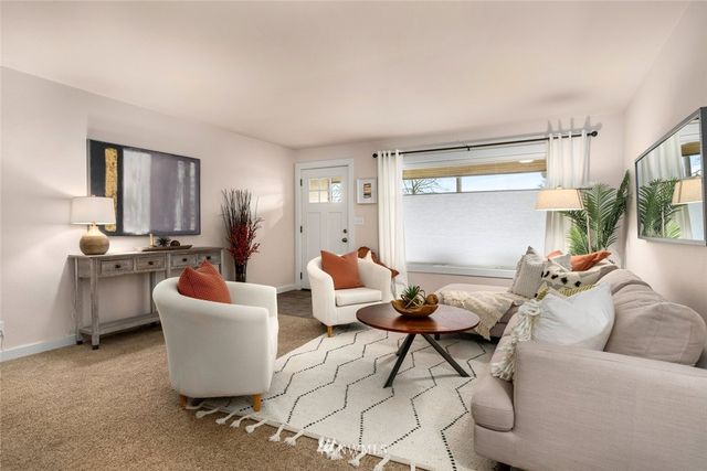 a living room with furniture a rug and a window