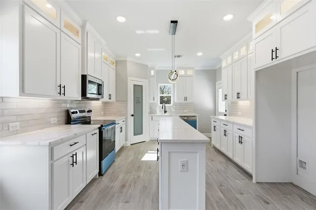a kitchen with a sink a counter top space stainless steel appliances and cabinets