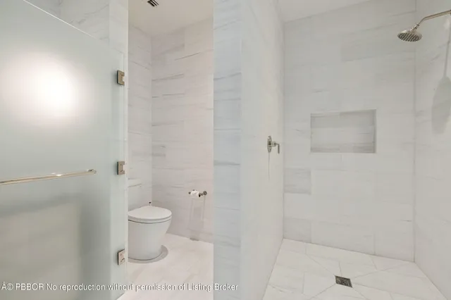 a bathroom with a toilet and a shower