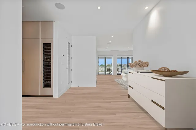 a large room with kitchen island white cabinets and wooden floor