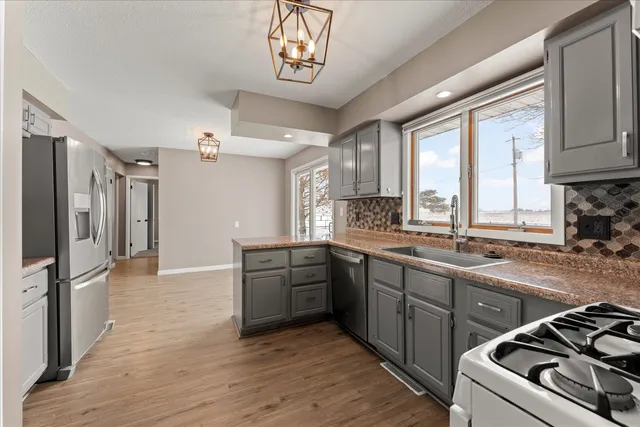 a kitchen with stainless steel appliances granite countertop a sink stove and refrigerator