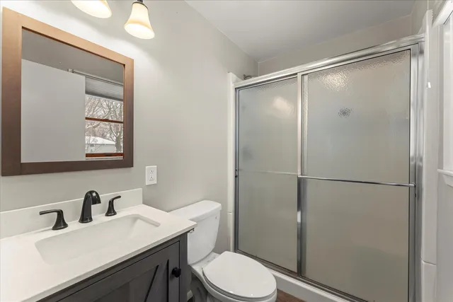 a bathroom with a sink vanity mirror and toilet