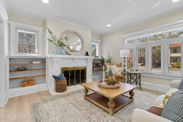 a living room with furniture a chandelier and a dining table