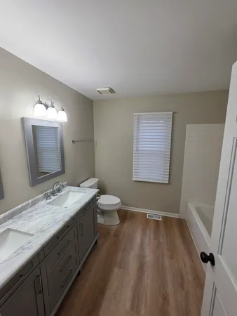 a bathroom with a granite countertop sink toilet a mirror and shower
