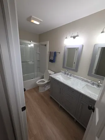 a bathroom with a double vanity sink toilet and shower