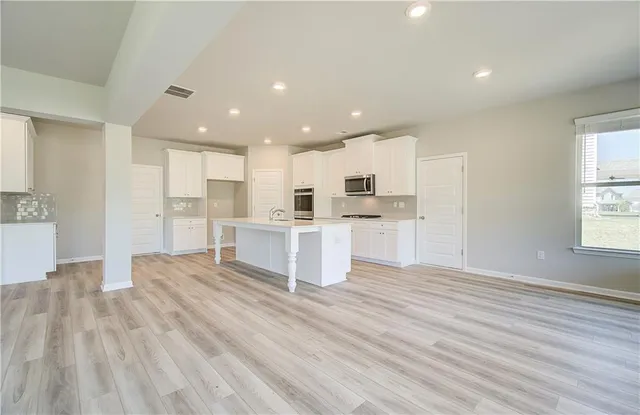a view of kitchen with wooden floor and electronic appliances