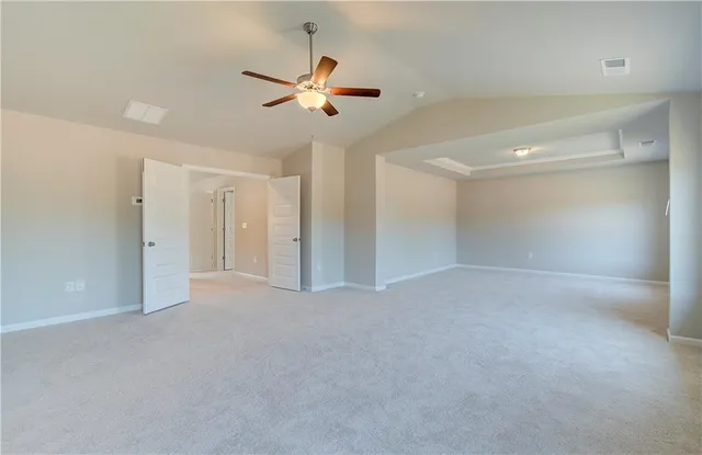 a view of an empty room with a chandelier fan
