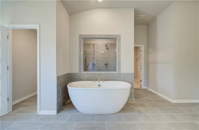 a bathroom with a bathtub and mirror