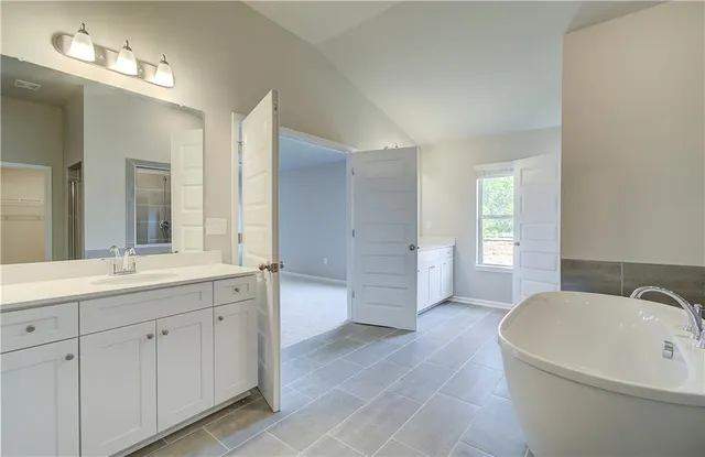 a bathroom with a tub sink and mirror